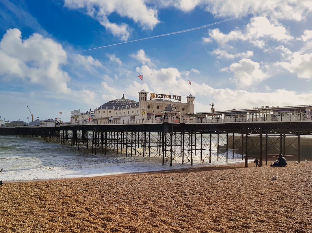 Brighton, Sussex: white concrete building near sea under blue sky during daytime